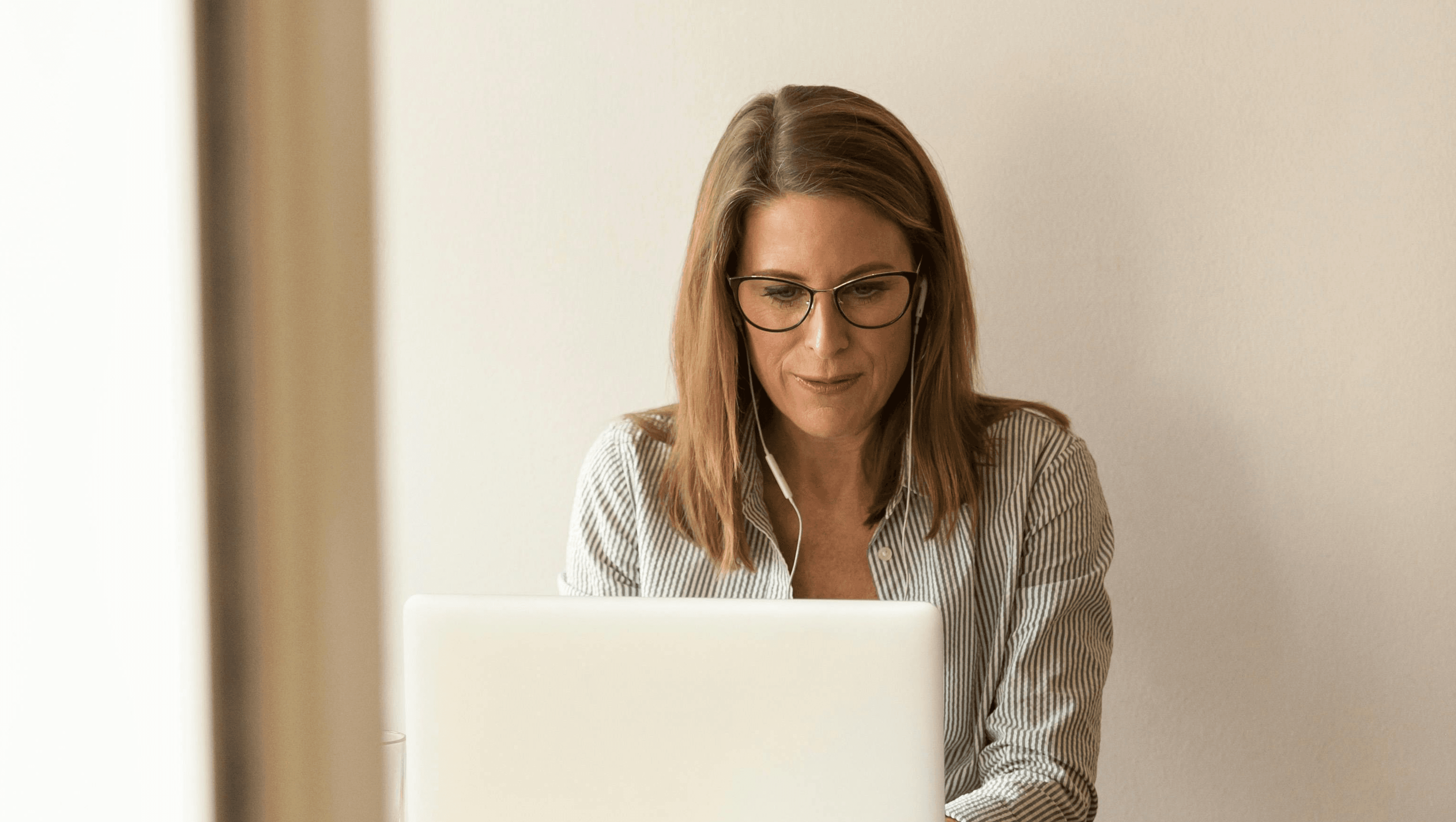 Headerbild zeigt Frau am Laptop mit Kopfhörern im Ohr, die die Prozessautomatisierung mithilfe von askDANTE vorantreibt.