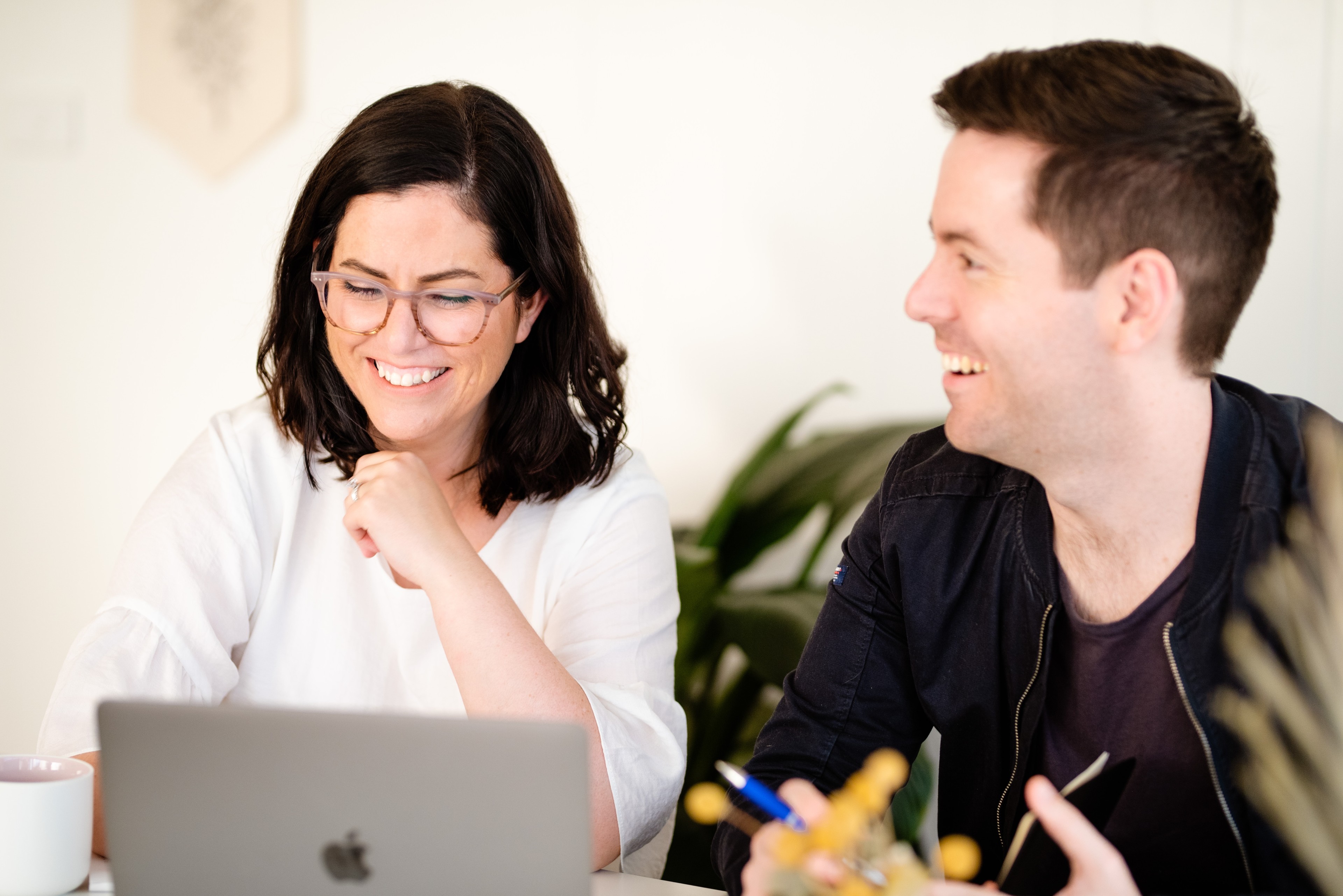 Zwei Mitarbeiter im Team arbeiten mit askDANTE am Laptop.