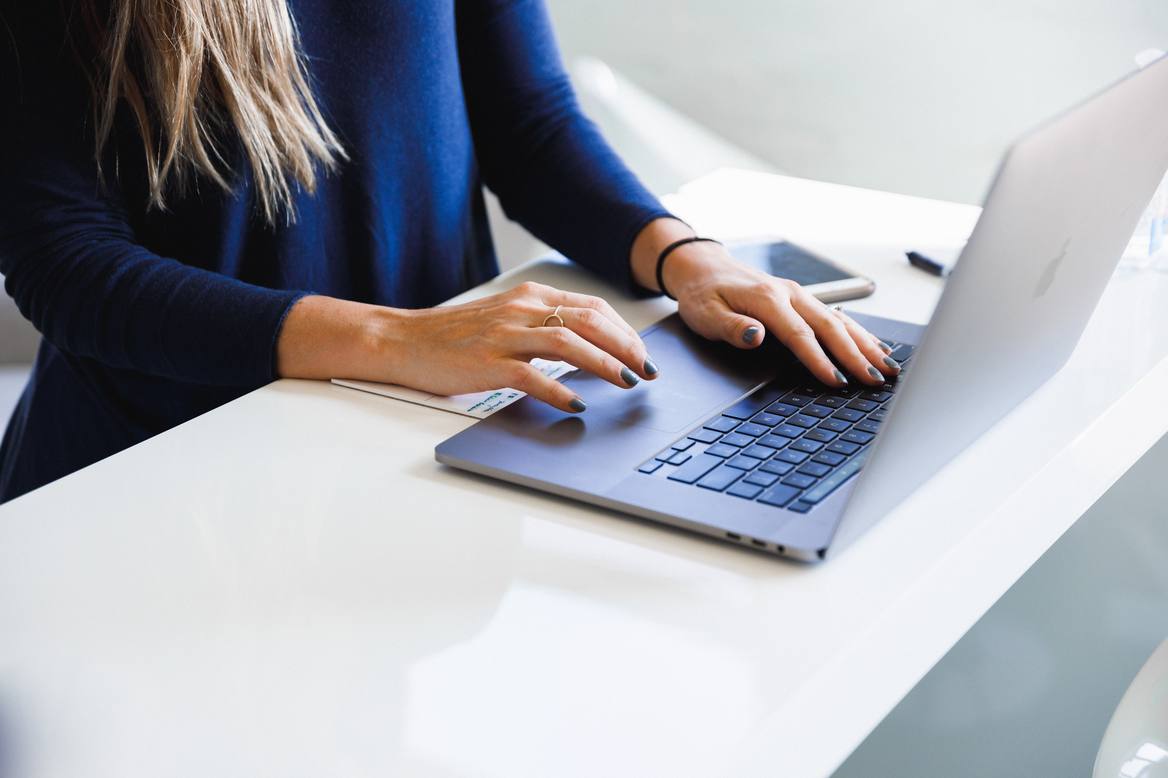 Haende an Tastatur von Mitarbeiterin, die mit askDANTE am Laptop arbeitet.