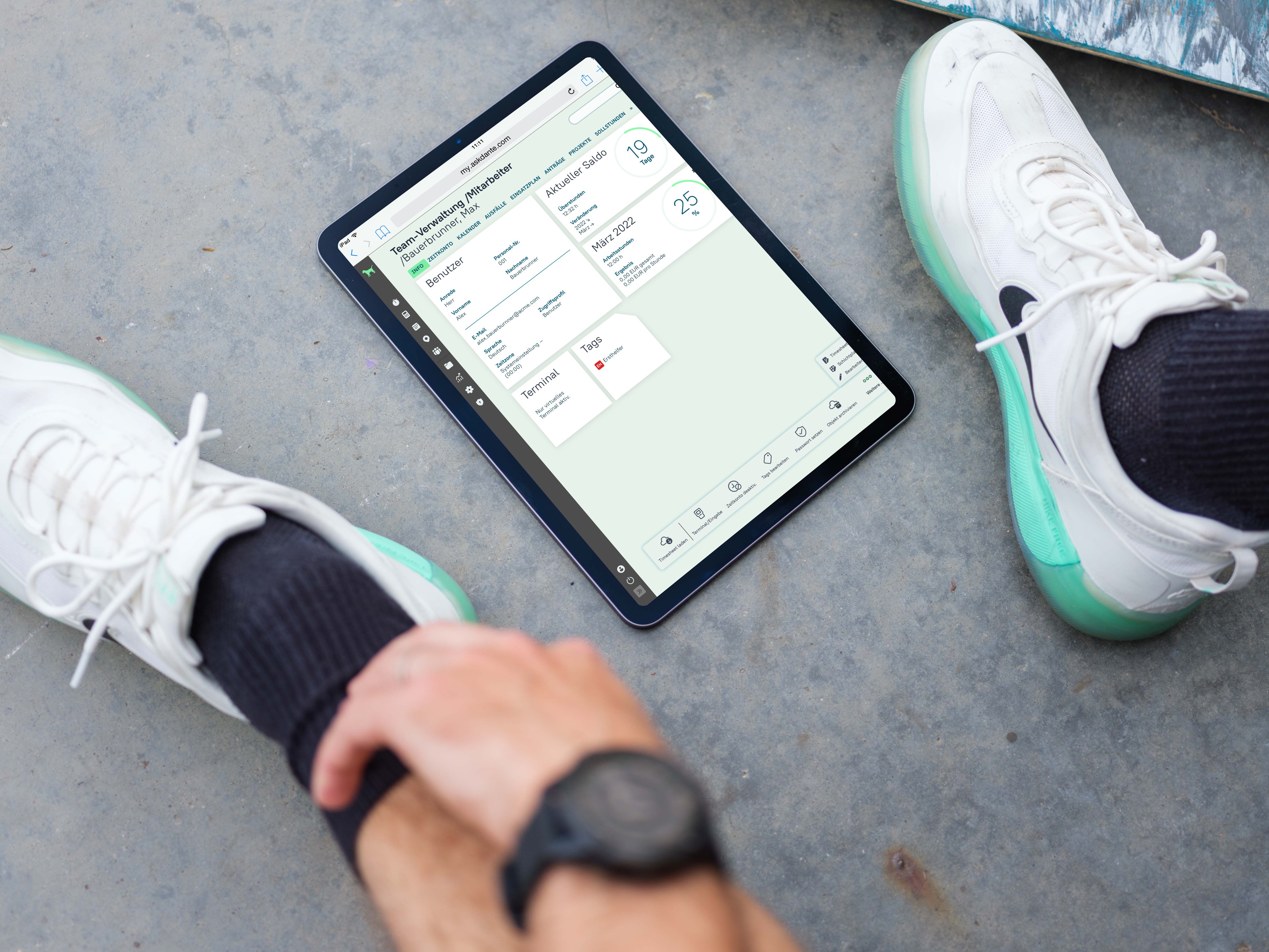 Mann sitzt neben iPod, das Überstunden und Zeiterfassung in askDANTE zeigt.