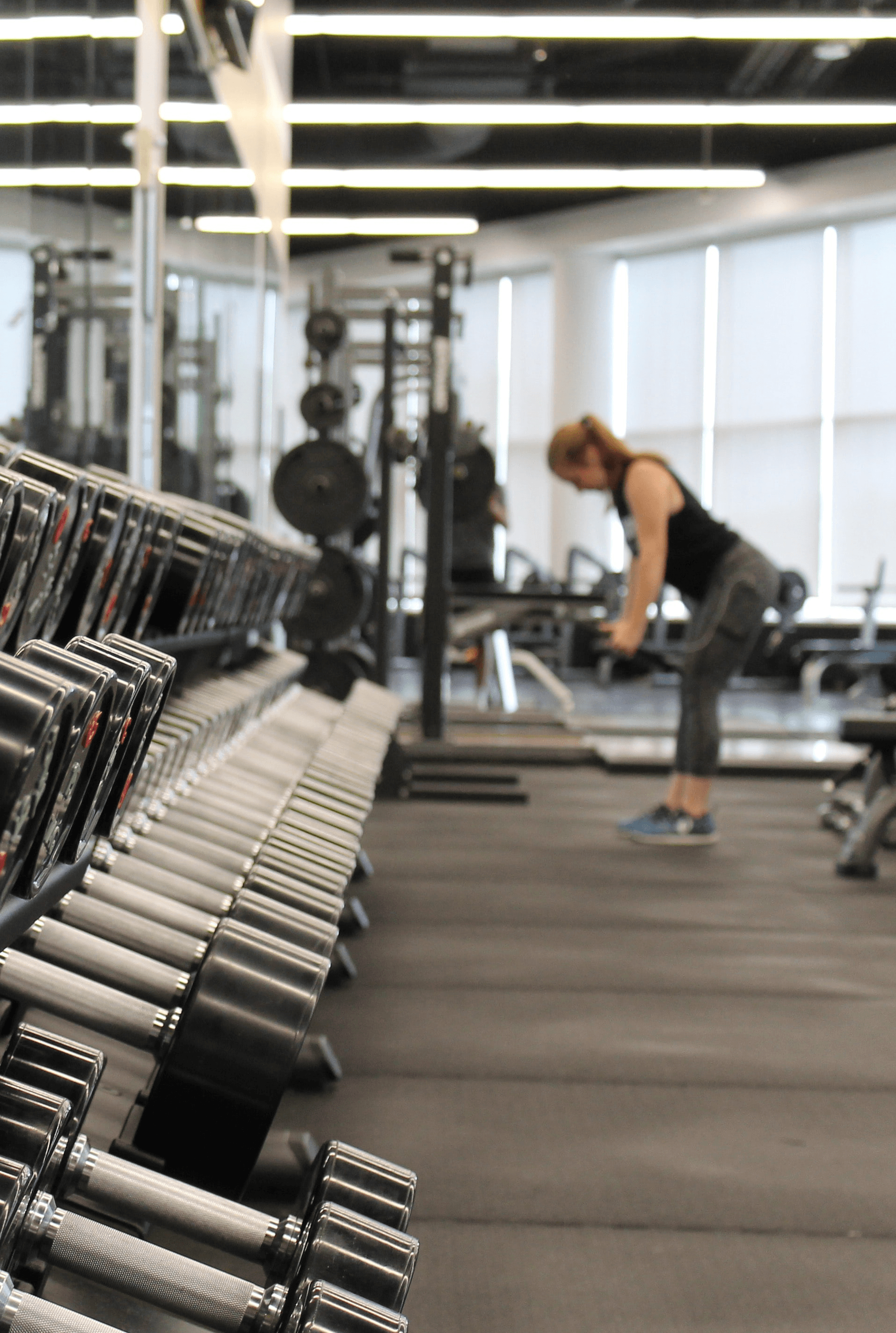 Frau mit Hanteln im Fitnesscenter, die Übungen macht.