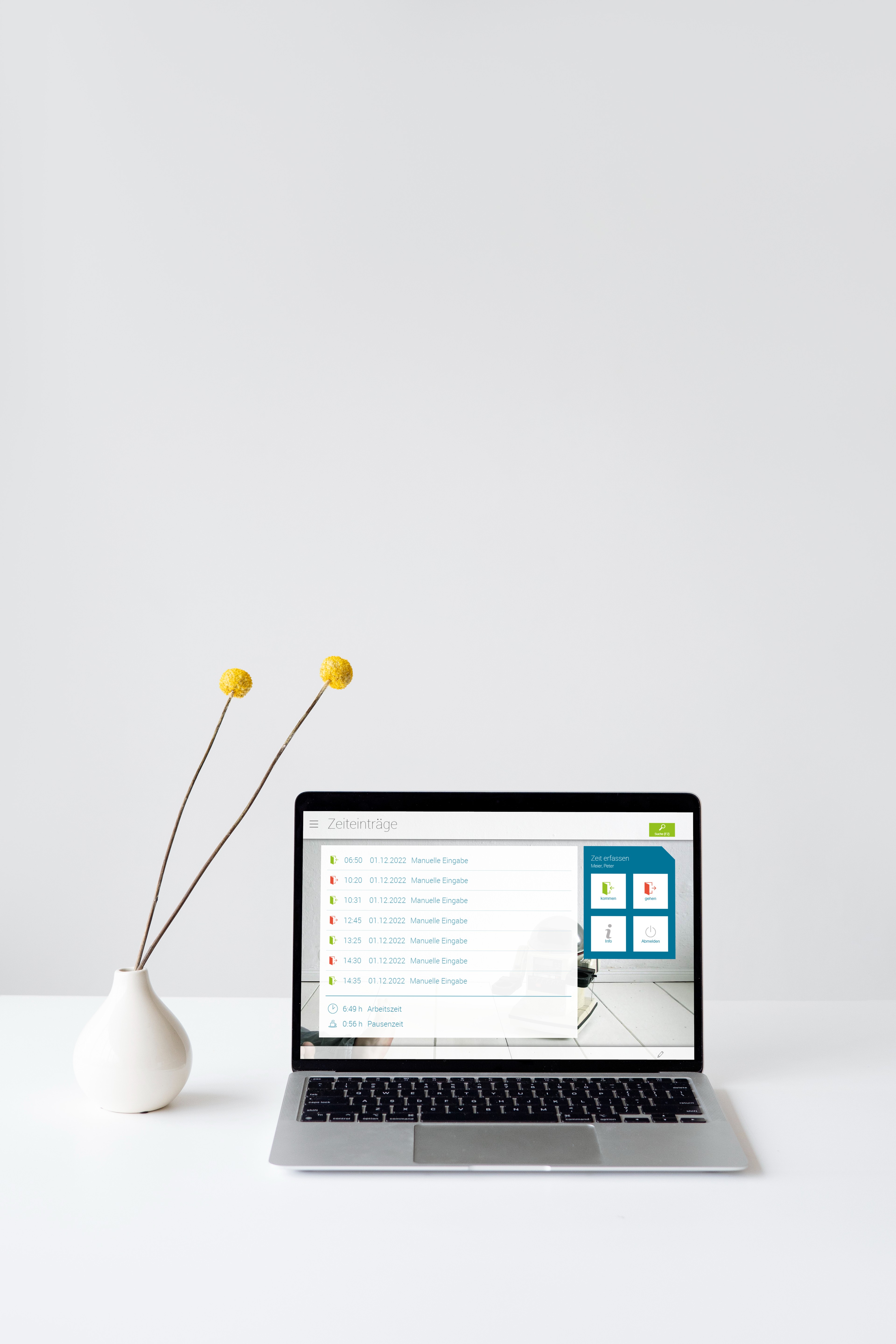 Laptop mit virtuellem Terminal von askDANTE Zeiterfassung. Daneben zwei gelbe Blumen in einer Vase.