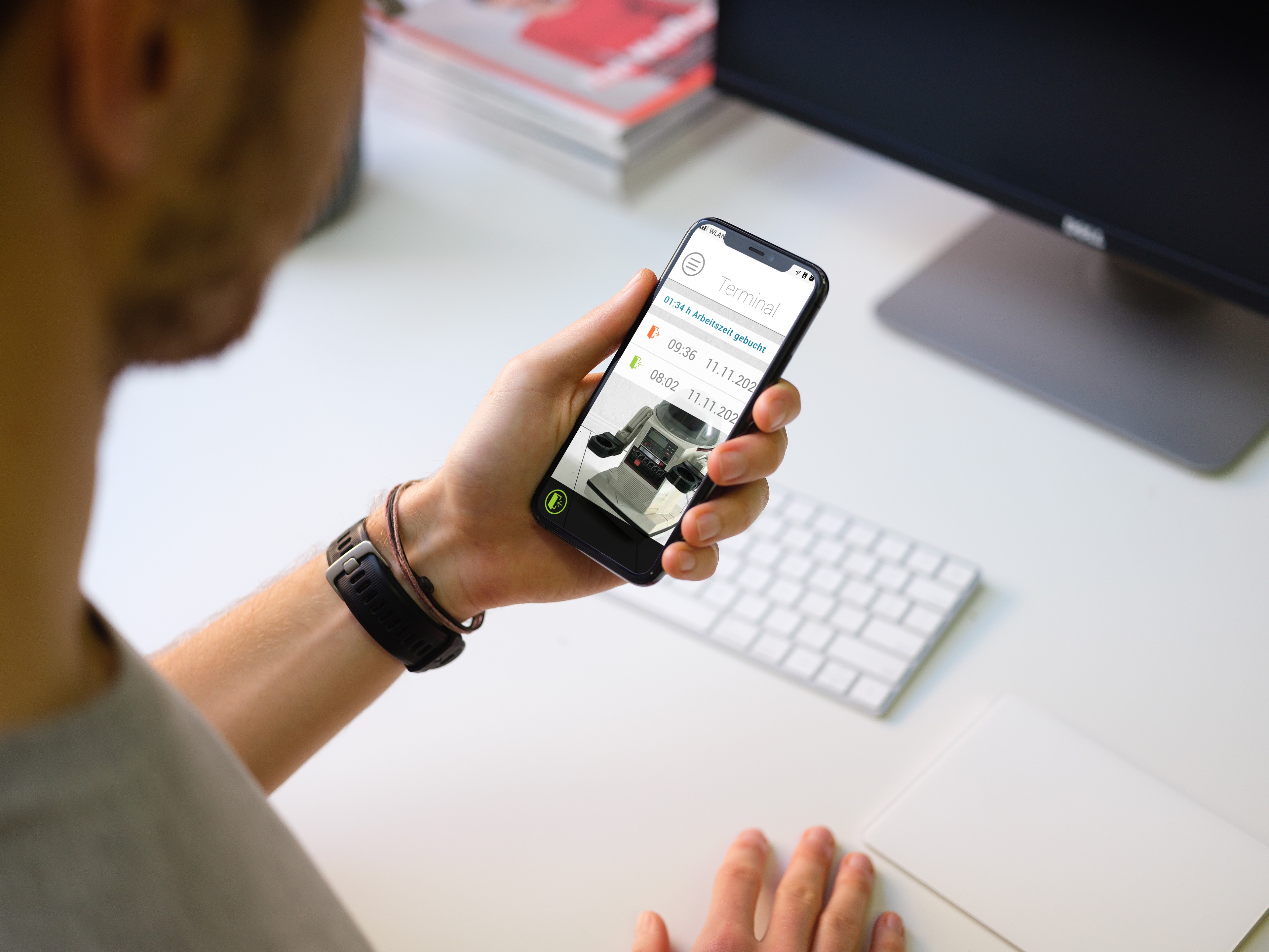 Mann mit Smartphone in der Hand, das eine Zeiterfassung am virtuellen Terminal von askDANTE zeigt.