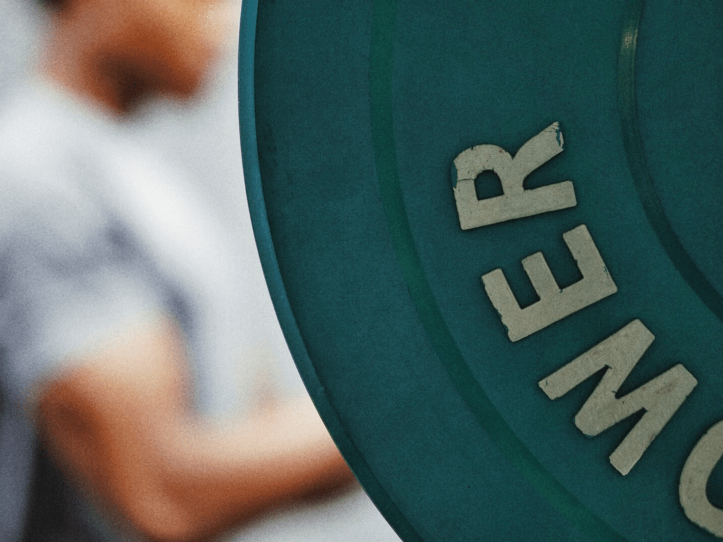 Ausschnitt einer Gewichthantel im Fitnessstudio mit Mann im Hintergrund