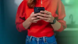 Header zeigt Frau mit Smartphone, die in der askDANTE Zeiterfassung mit App arbeitet.