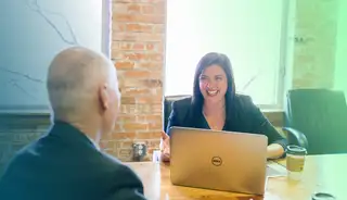 Headerbild mit Mitarbeiterin und Mitarbeiter am Tisch, die mit askDANTE am Laptop arbeiten.