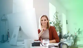 Header zeigt Frau mit Monitor im Buero, die mit askDANTE zum Thema Kurzarbeit arbeitet.