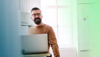 Header zeigt Mitarbeiter am Laptop, der die eAU Abfrage in der Zeiterfassung askDANTE nutzt.