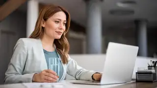 Headerbild zeigt eine Frau vor dem Laptop, die den online Arbeitszeitrecher von askDANTE nutzt, um ihre Arbeitszeit zu berechnen.