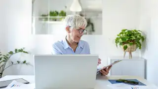 Headerbild mit einer Mitarbeiterin vor dem Laptop im Homeoffice, die ihre Altersteilzeit mithilfe von askDANTE am Klemmbrett plant.