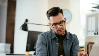 Headergrafik zeigt einen Mitarbeiter, der mithilfe von askDANTE prüft, ob seine Minusstunden durch den Arbeitgeber verursacht wurden.