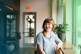 Header zeigt Angestellte, die im Office am Tisch im Rahmen der Vier-Tage-Woche sitzt.Header zeigt Angestellte, die im Office am Tisch im Rahmen der Vier-Tage-Woche sitzt.