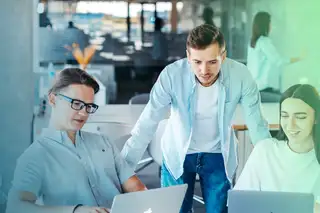 Headerbild zeigt drei Mitarbeiter, die mit Laptops den Urlaubsplaner online mit askDANTE bearbeiten.