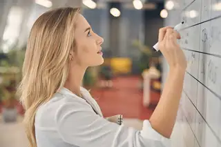 Headerbild zeigt Mitarbeiterin, die am Whiteboard den FTE für die HR Abteilung berechnet.