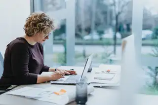 hrmanagerin arbeitet am laptop am schreibtisch im hellen buero